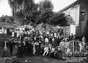 Grupo de pessoas reunidas por ocasião do batizado de Júlio Eberle, realizado no Veraneio e Balneário Germani. Caxias, c. 1910. Autoria: Domingos Mancuso. Doação: Francisco Fortuna. Fundo Domingos Mancuso. Acervo: AHMJSA.