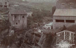Vista do arroio Marquês do Herval (Tega), tendo à direita o Moinho de Aristides Germani. Foto colorizada à mão. Caxias, [c. 1912]. Autoria não identificada. Fundo Família Sassi. Acervo: AHMJSA.